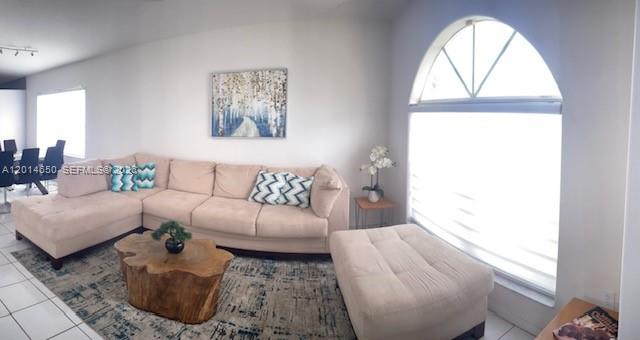 A living room features a beige sectional sofa, a wooden coffee table, and an arched window — 16654 SW 103rd Ln, Miami FL 33196, MIAMI, FL