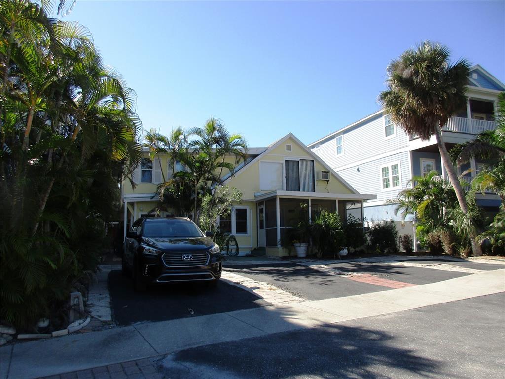 A yellow house with a screened porch and a black SUV parked in the driveway — 618 AVENIDA DE MAYO, SARASOTA, FL