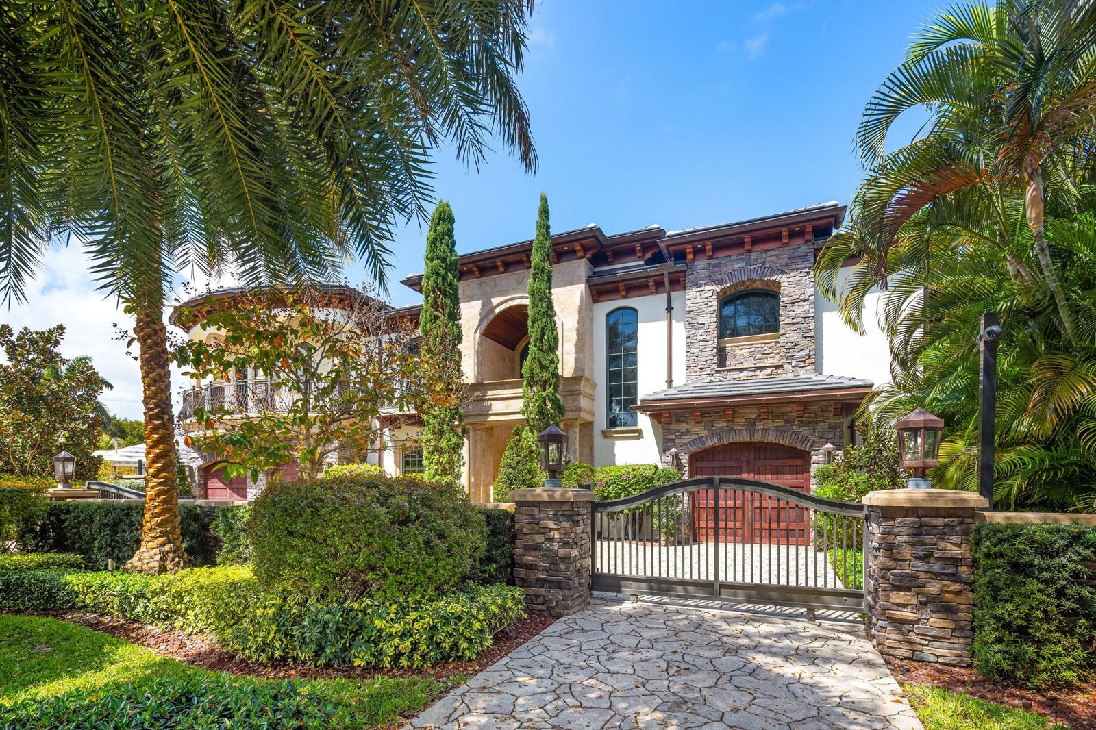 A formal living room features wood-paneled walls, a large crystal chandelier, and a grand piano — 2325 NE 27th Street, Lighthouse Point FL 33064, LIGHTHOUSE POINT, FL