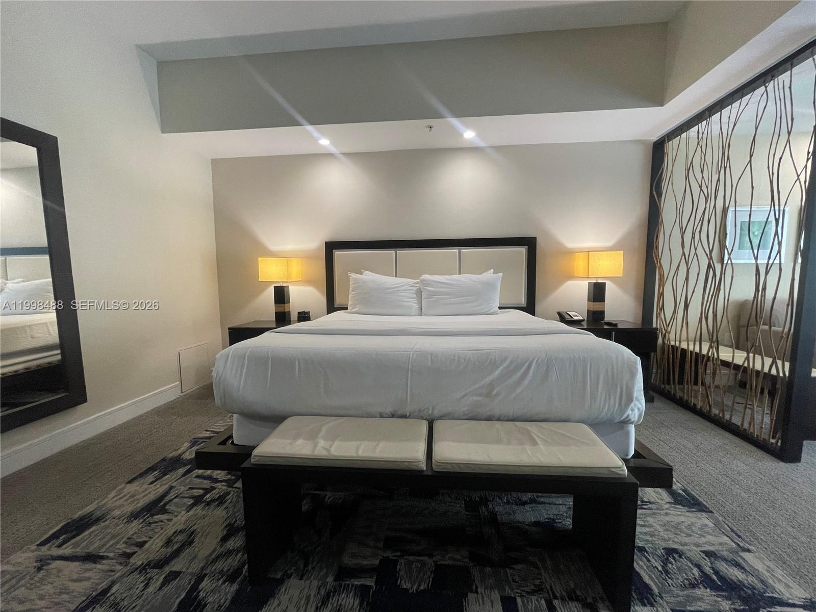 A bedroom features a king bed, two nightstands with lamps, and a decorative branch screen — 5300 NW 87th Ave # 1103, Doral FL 33178, DORAL, FL