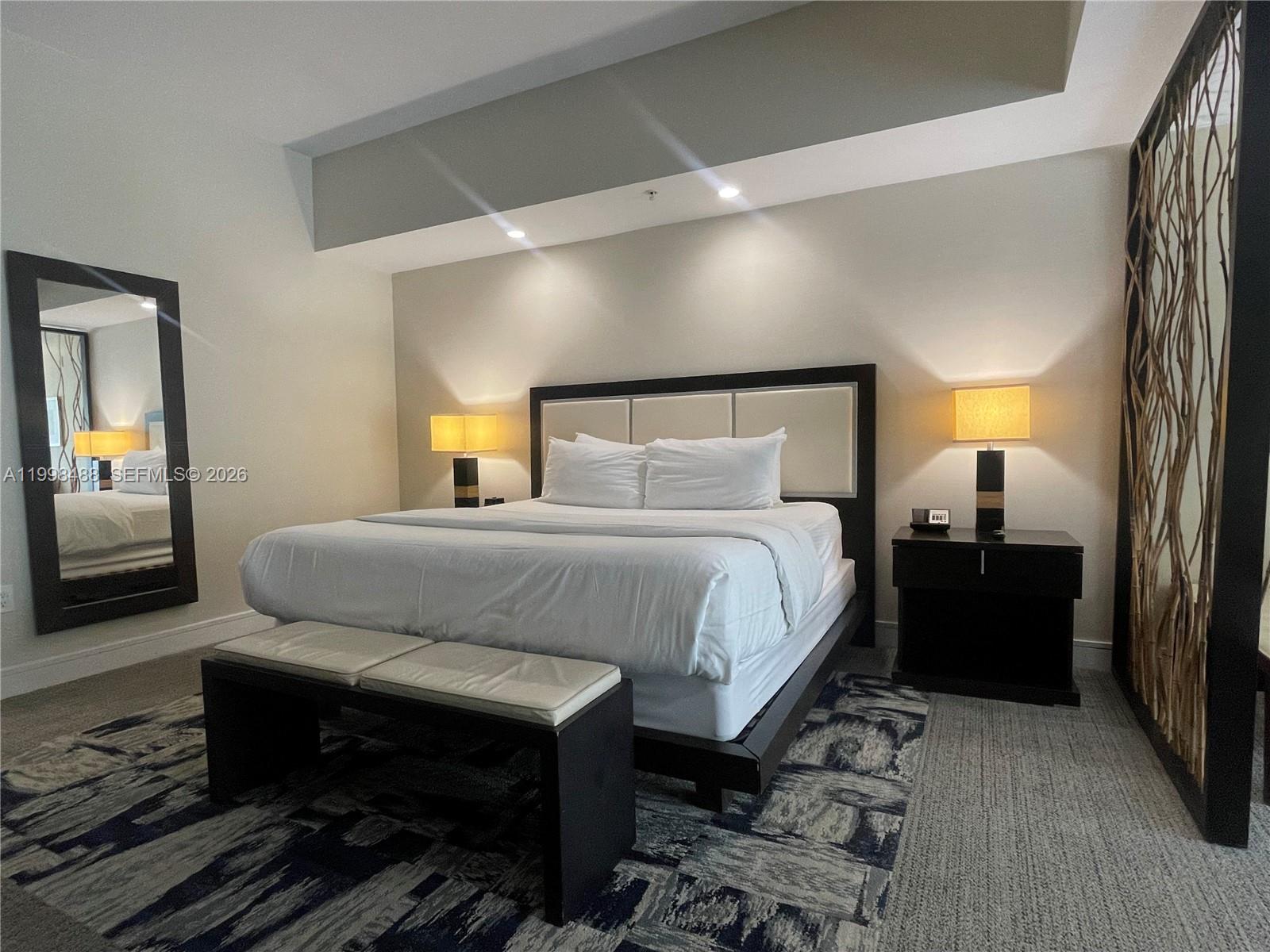 A bedroom features a king bed, two nightstands with lamps, a bench, and a mirror — 5300 NW 87th Ave # 1103, Doral FL 33178, DORAL, FL