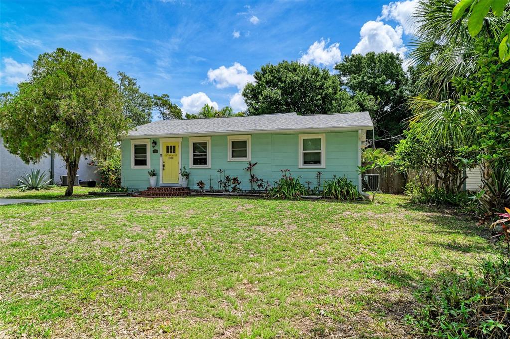 A light green single-story house with a yellow front door sits on a grassy lot — 508 16TH AVENUE W, PALMETTO, FL