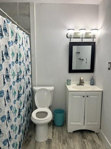 A bathroom features a seashell-patterned shower curtain, a white toilet, and a vanity with a mirror — 265 NW 80th St, Miami FL 33150, MIAMI, FL