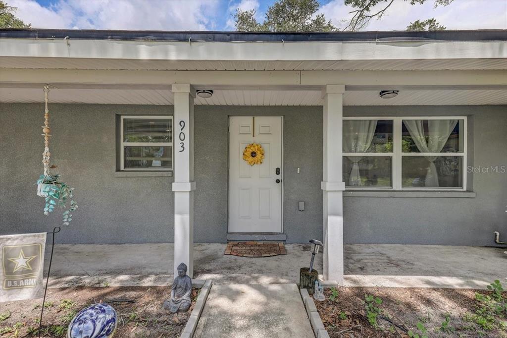 The exterior of a gray house features a covered porch, white columns, and a front door — 903 N BRACEWELL DRIVE, PLANT CITY, FL