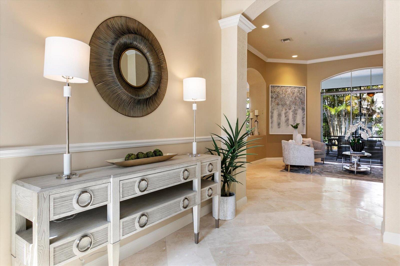 A bright entryway features a light wood console table, two lamps, and a circular wall mirror — 6059 Bither Way, Lake Worth FL 33467, LAKE WORTH, FL