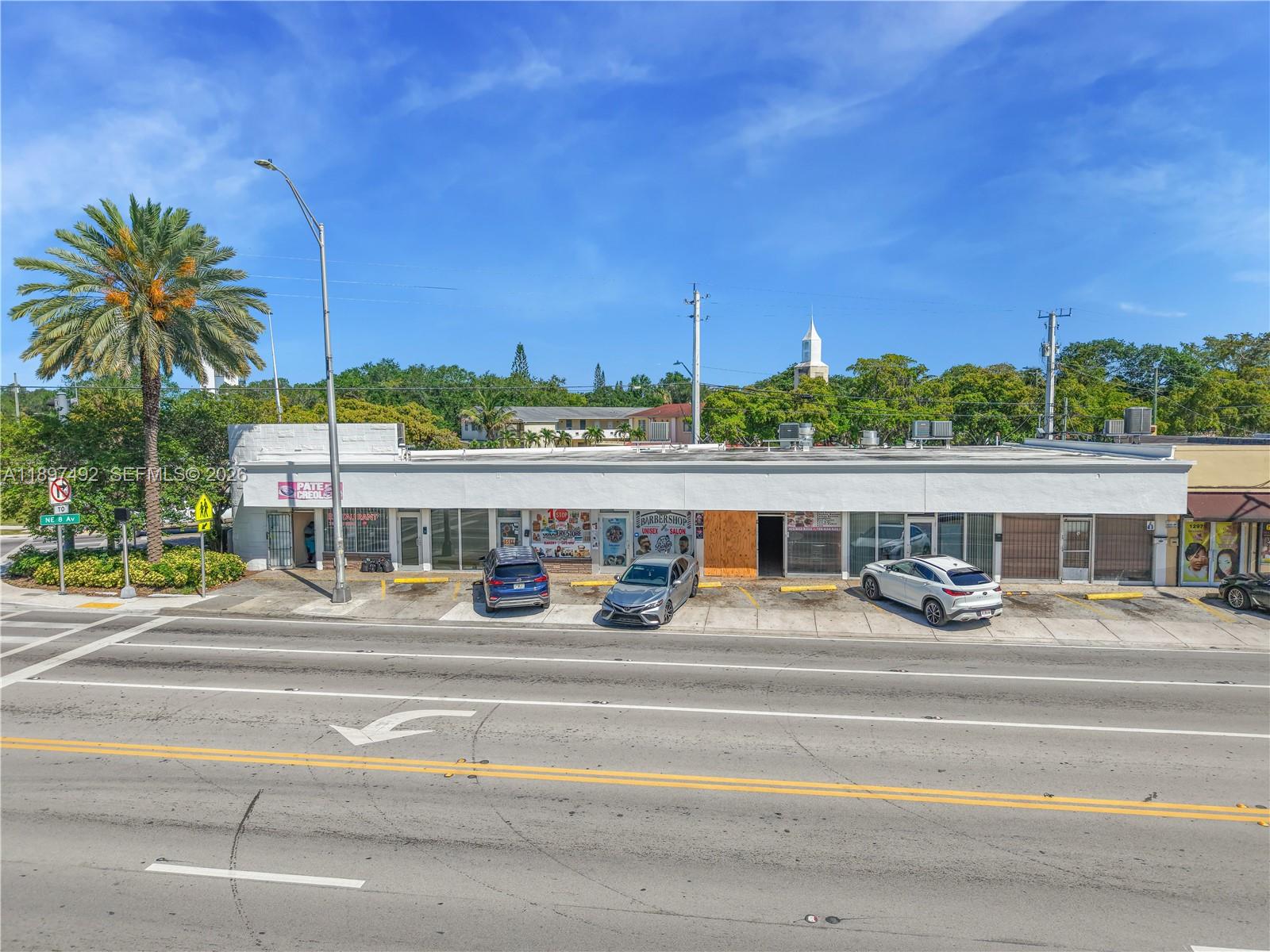 An exterior view of a single-story commercial strip mall with parked cars in front — 12985 W Dixie Hwy, North Miami FL 33161, NORTH MIAMI, FL