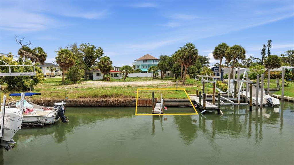 A waterfront lot features a wooden dock and bulkhead along a canal with boats — 1949 PENNSYLVANIA AVENUE UNIT BL1, ENGLEWOOD, FL