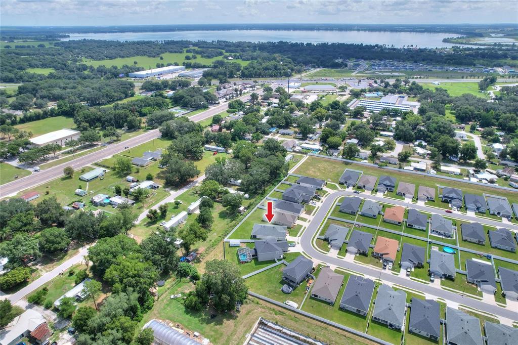 An aerial view shows a suburban neighborhood with a red arrow pointing to a house — 6360 GARDNER DRIVE, LAKELAND, FL