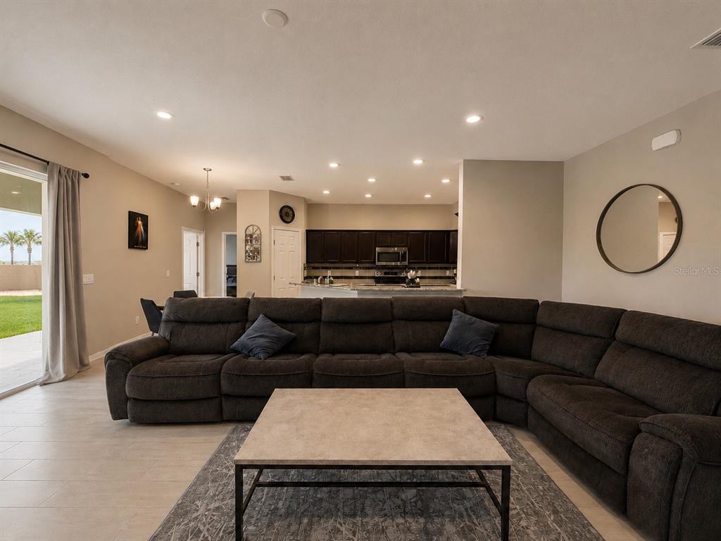 A living room features a large dark sectional sofa, a coffee table, and an open kitchen — 4539 CALUMET DRIVE, ST CLOUD, FL