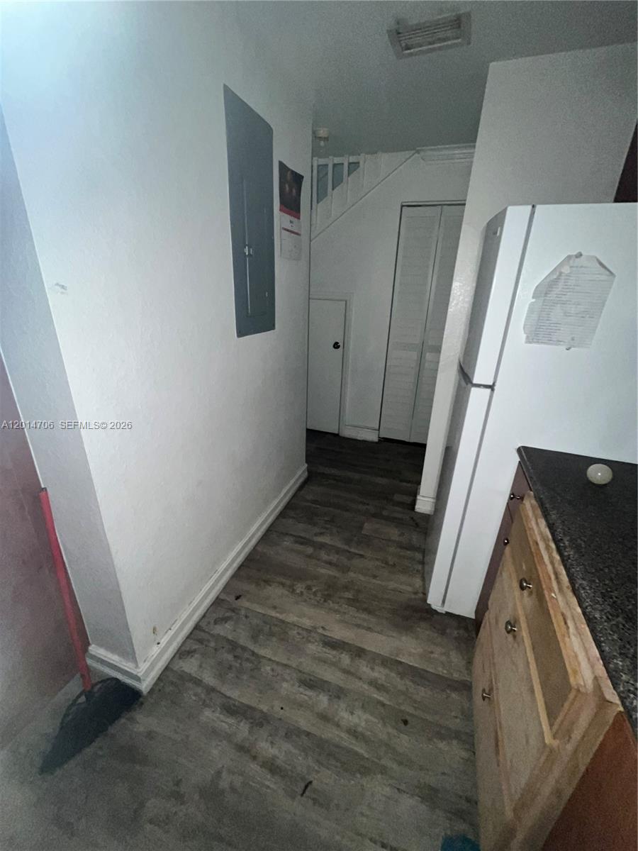 A kitchen hallway features wood-look flooring, a white refrigerator, and a staircase — 2286 NW 136th Ter # 0, Opa-Locka FL 33054, OPA-LOCKA, FL