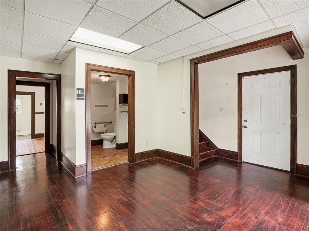 An interior room features dark hardwood floors, white walls, a drop ceiling, and three doorways — 1214 E LIVINGSTON STREET STREET, ORLANDO, FL