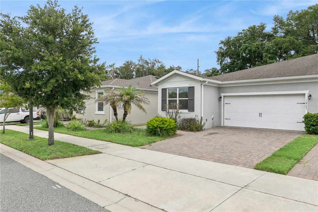A single-story house with a white garage door, a paved driveway, and a front lawn — 1863 SHUMARD AVENUE UNIT 1863, ST CLOUD, FL