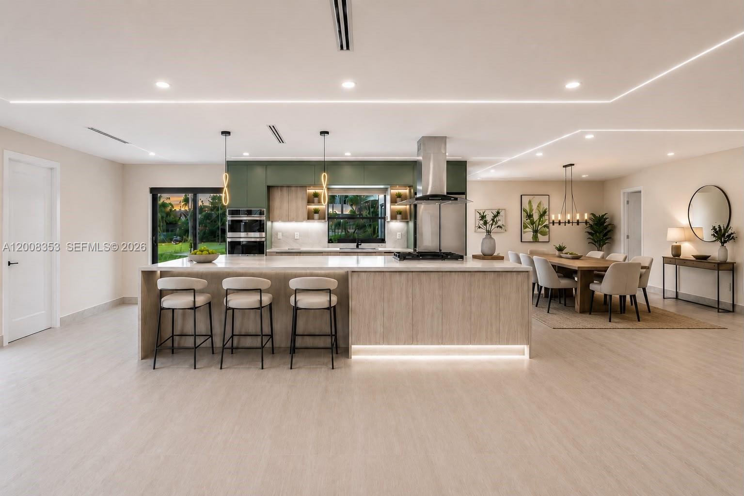 A modern kitchen features a large island, green cabinetry, and an adjacent dining area — 4700 SW 110th Ave, Davie FL 33328, DAVIE, FL