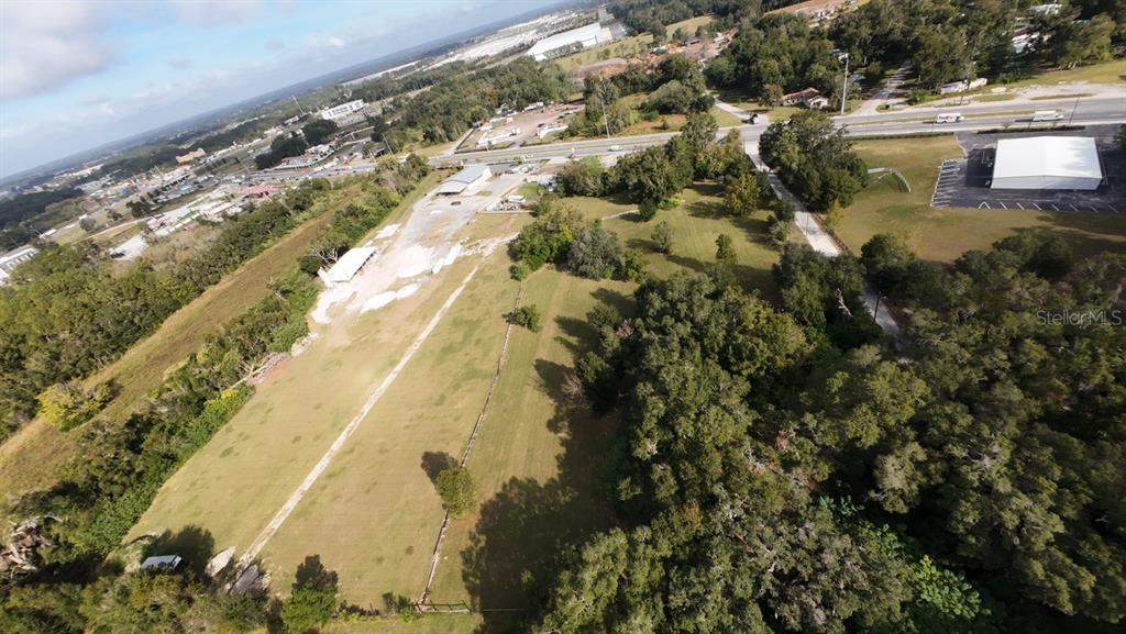 An aerial view shows a large, grassy rectangular lot bordered by trees and nearby roads — 3308 NW BLITCHTON ROAD, OCALA, FL