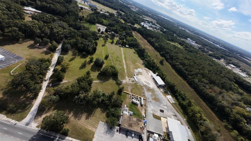 An aerial view shows a large grassy lot with several buildings and a paved road — 3308 NW BLITCHTON ROAD, OCALA, FL