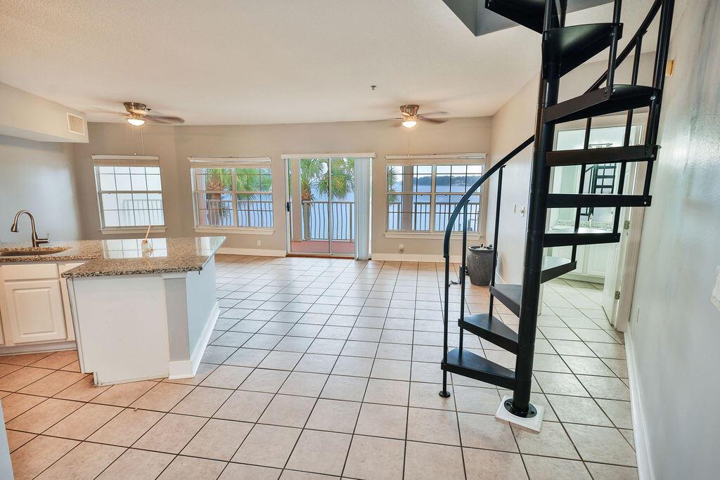 A kitchen and living area with tile floors, a spiral staircase, and a waterfront balcony — 5 Laguna Street # 205, FL 32548, FL