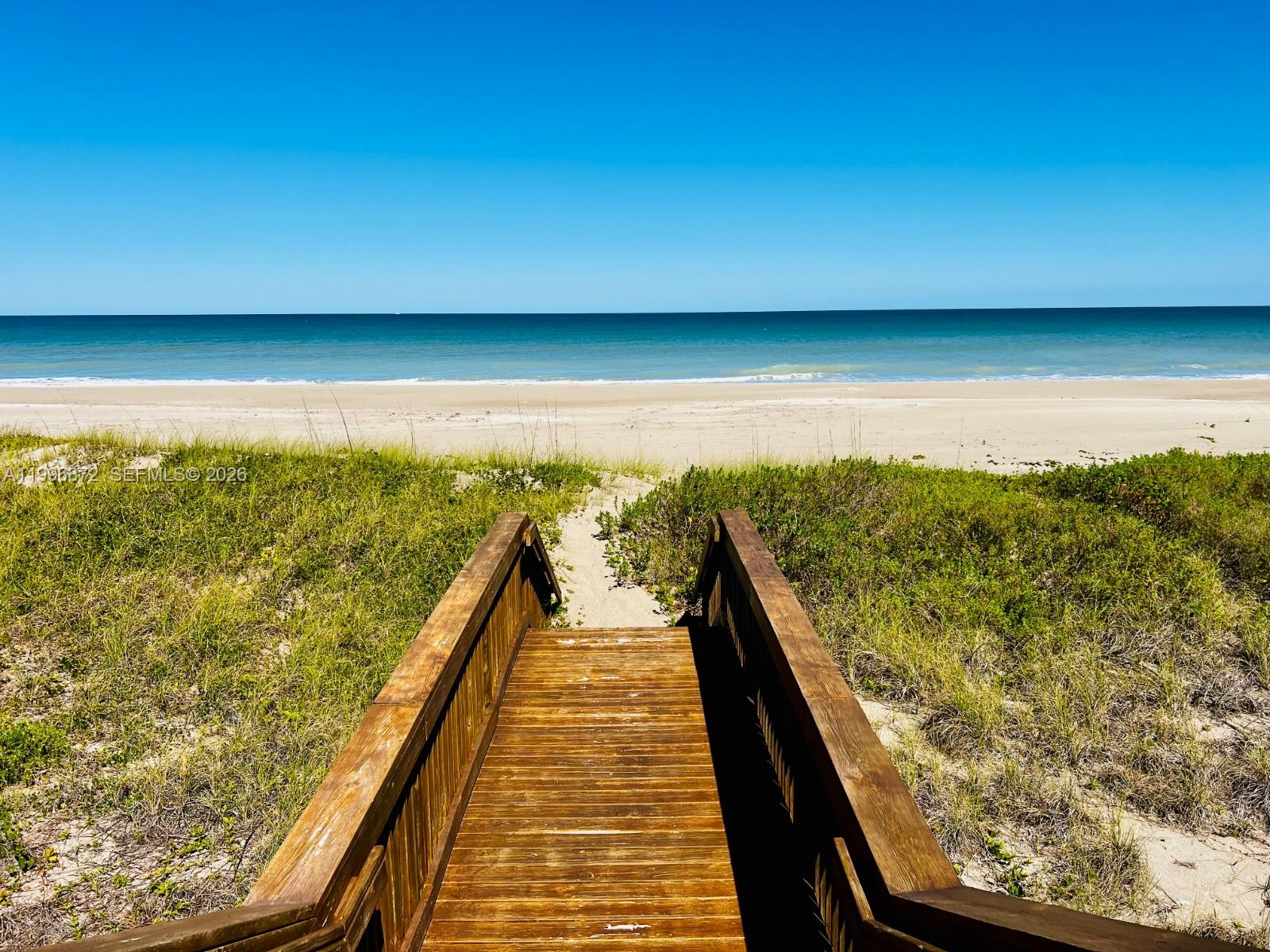 A wooden boardwalk leads through sand dunes to a sandy beach and the ocean — 4803 Watersong Way, Fort Pierce FL 34949, FORT PIERCE, FL