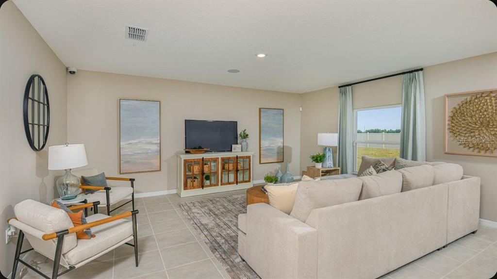 A living room features a beige sofa, two armchairs, a television console, and tile flooring — 6786 EQUINOX LANE, NORTH FORT MYERS, FL