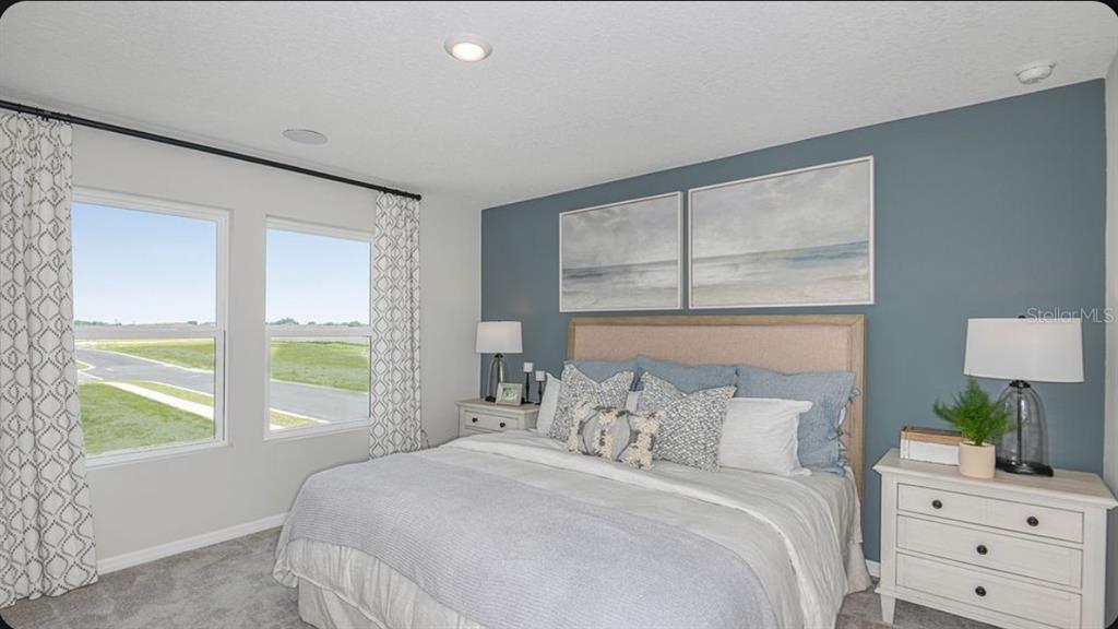 A bedroom features a blue accent wall, a beige upholstered headboard, and two windows — 6786 EQUINOX LANE, NORTH FORT MYERS, FL