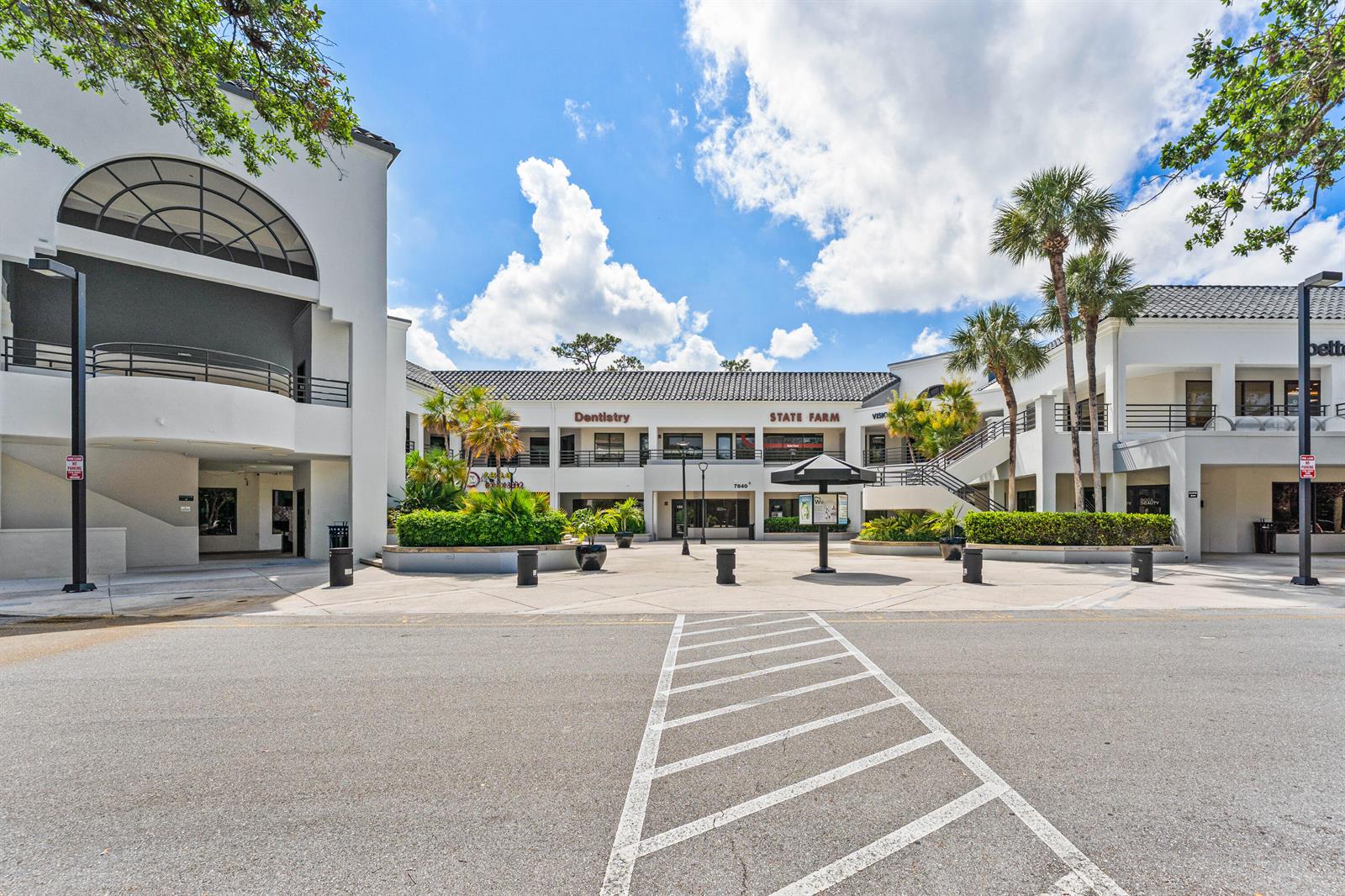 A two-story commercial building features a central courtyard with palm trees and outdoor staircases — 7880 Glades Road, Boca Raton FL 33434, BOCA RATON, FL