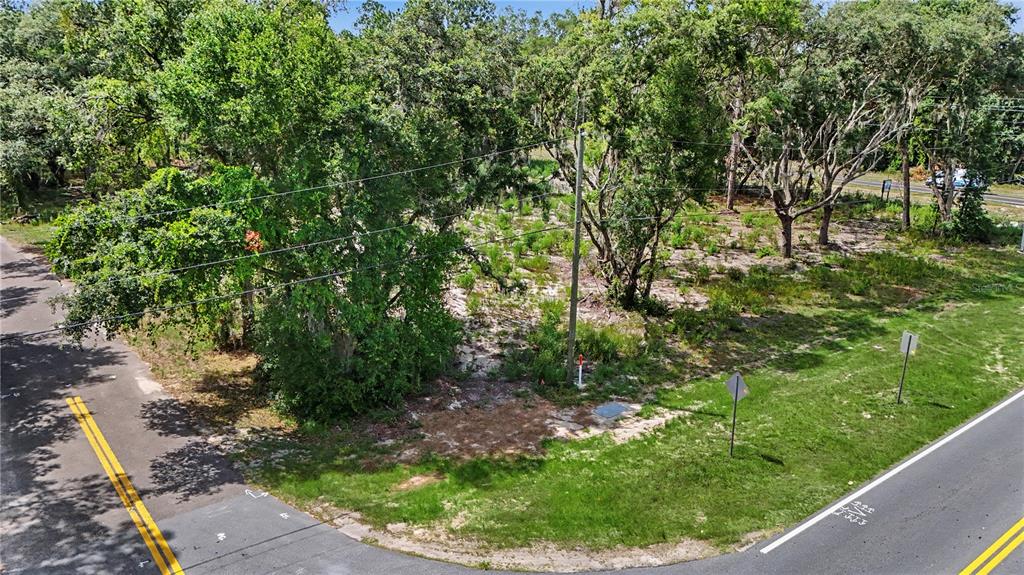 An elevated view of a vacant, tree-covered corner lot bordered by two paved roads — 3 BAY DRIVE, OCKLAWAHA, FL