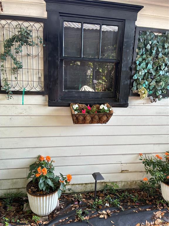 A black-framed window with a flower box is centered on a white-sided exterior wall — 407 N SHINE AVENUE, ORLANDO, FL