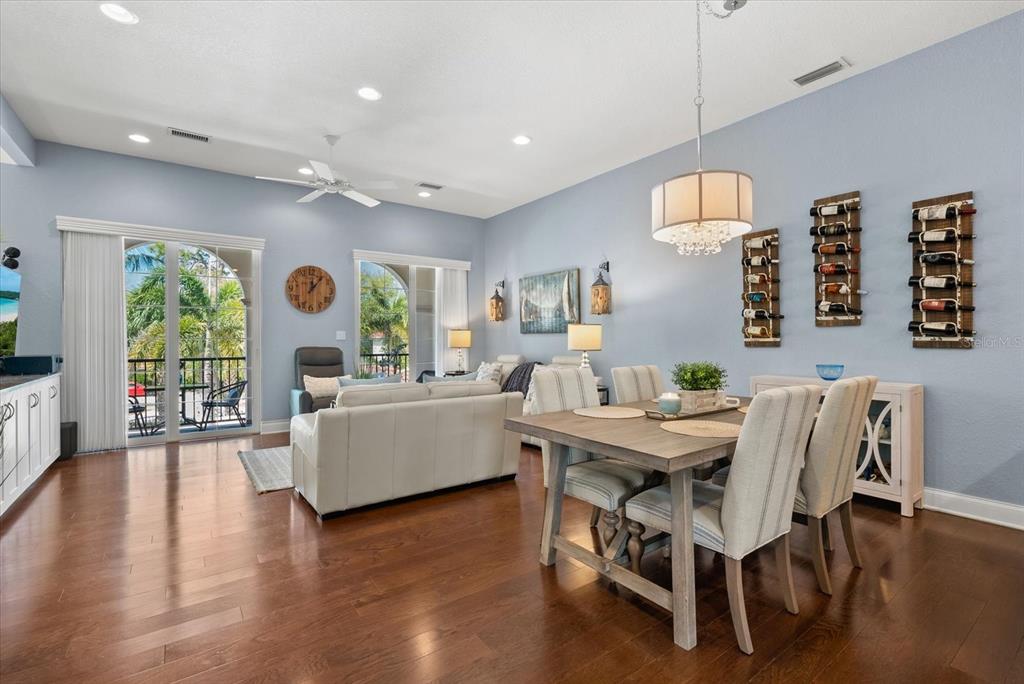 A dining area and living room with light blue walls, hardwood floors, and a balcony — 429 NOKOMIS AVENUE S, VENICE, FL