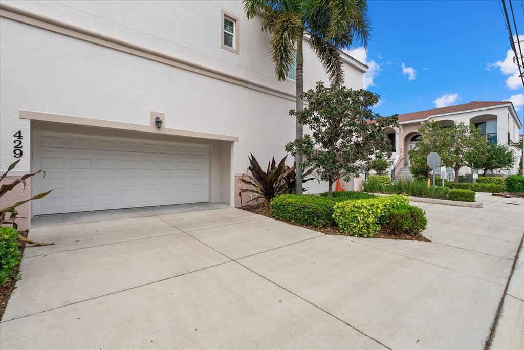 A white building with a two-car garage and a palm tree in the front yard — 429 NOKOMIS AVENUE S, VENICE, FL