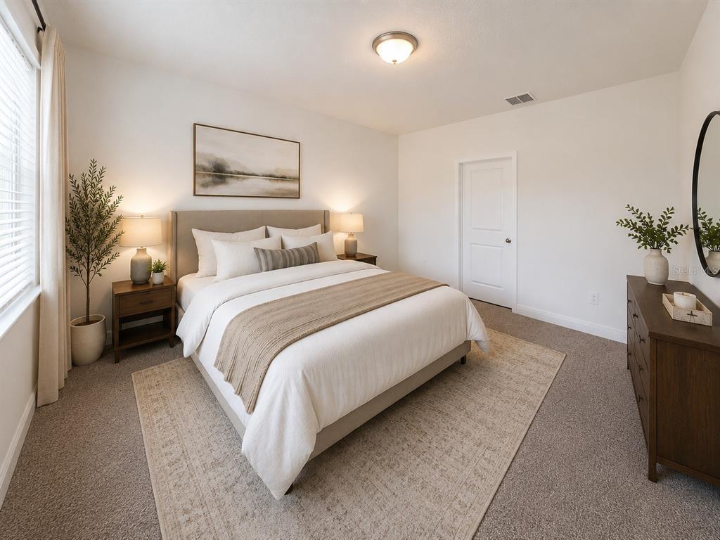 A bedroom features a bed with neutral bedding, two nightstands, a dresser, and a rug — 1789 ARCHER DRIVE, MINNEOLA, FL