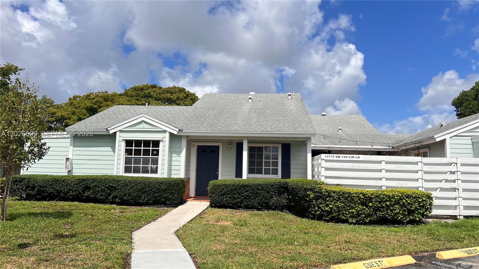 A light green single-story house features a dark blue front door and a white fence — 13775 SW 149th Cir Ln # 86, Miami FL 33186, MIAMI, FL