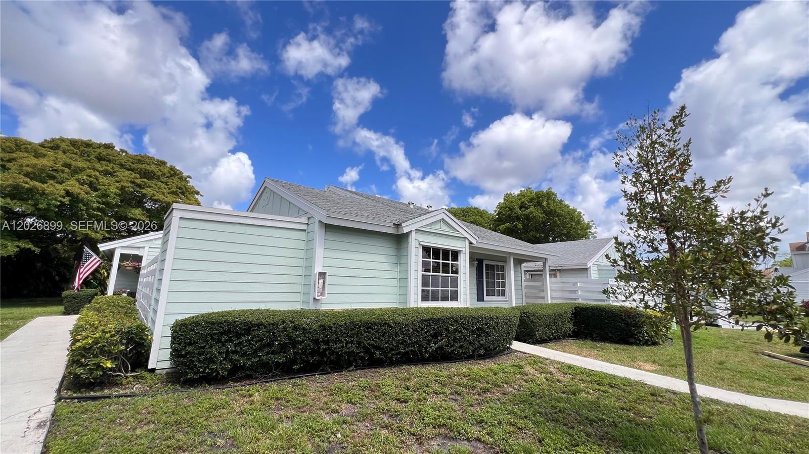 A light green, single-story house features horizontal siding, a gray shingled roof, and manicured hedges — 13775 SW 149th Cir Ln # 86, Miami FL 33186, MIAMI, FL