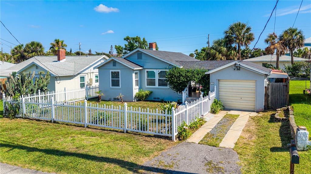 A light blue house with a white picket fence and a single-car garage — 129 ROSALYN AVENUE, DAYTONA BEACH, FL