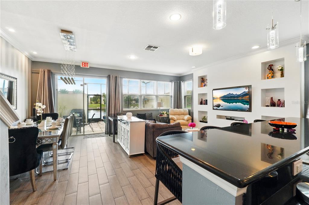 An open-concept living and dining area features tile floors, a kitchen island, and sliding doors — 3115 TOCOA CIRCLE, KISSIMMEE, FL