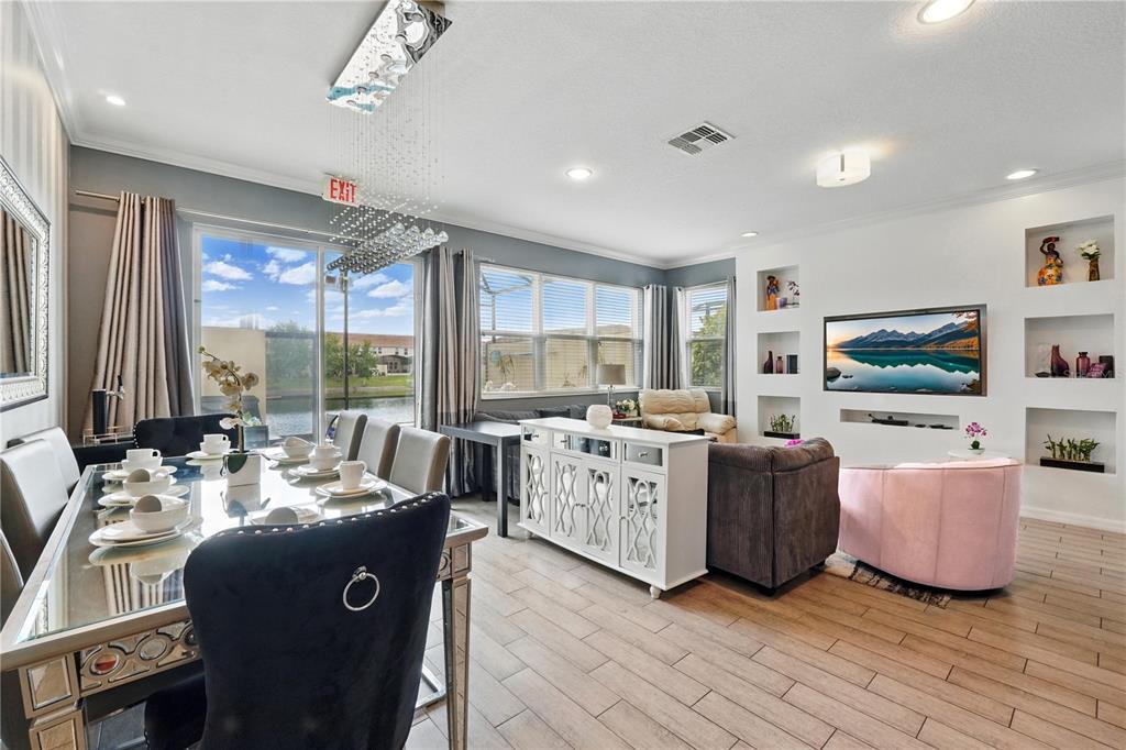 A dining area and living room feature tile flooring, a crystal chandelier, and lake views — 3115 TOCOA CIRCLE, KISSIMMEE, FL