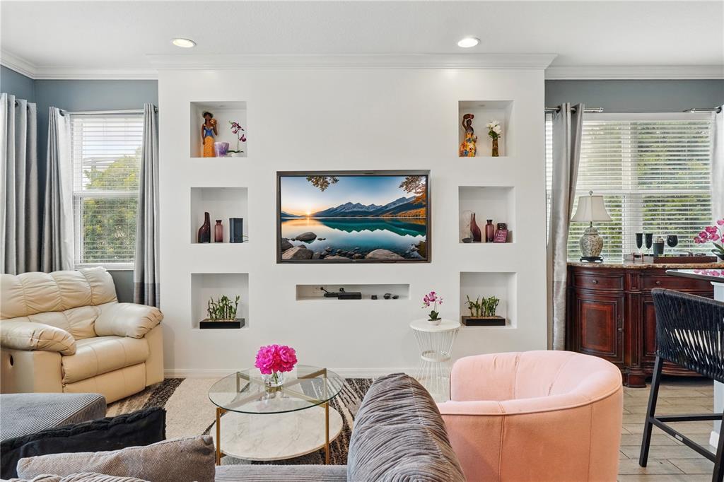 A living room features a white wall with built-in niches surrounding a mounted television — 3115 TOCOA CIRCLE, KISSIMMEE, FL