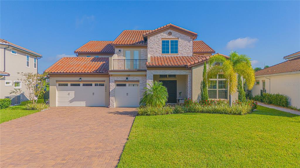 A two-story house with a tiled roof, stone facade, and a two-car garage — 10846 MOBBERLEY CIRCLE, ORLANDO, FL