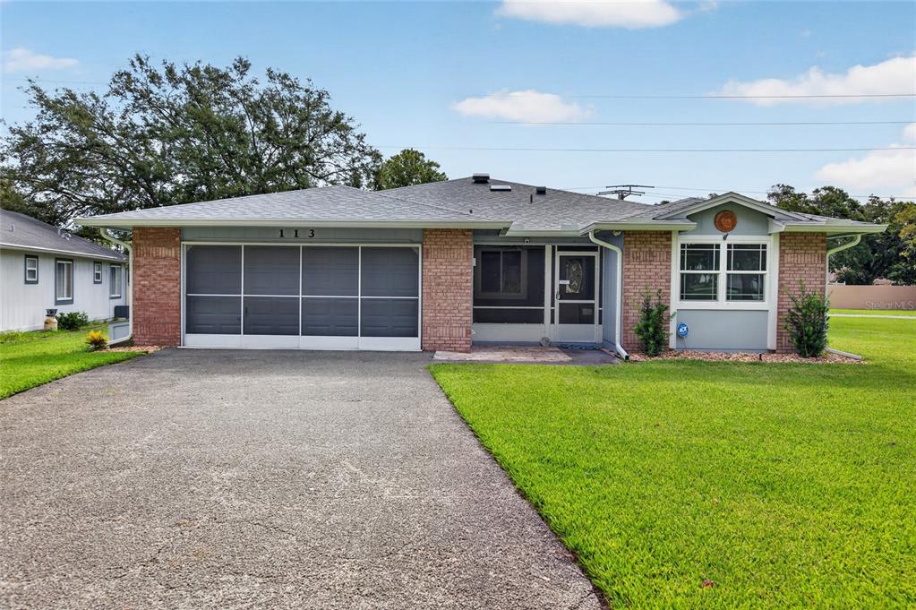 A single-story house with a brick facade, a two-car garage, and a front lawn — 113 DUSK MEADOW TRAIL, PORT ORANGE, FL
