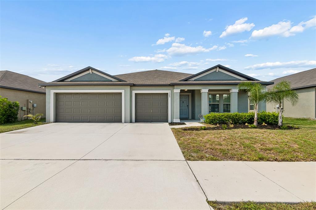 A single-story house with a two-car garage, a covered entryway, and a concrete driveway — 1565 COLDING DRIVE, RUSKIN, FL