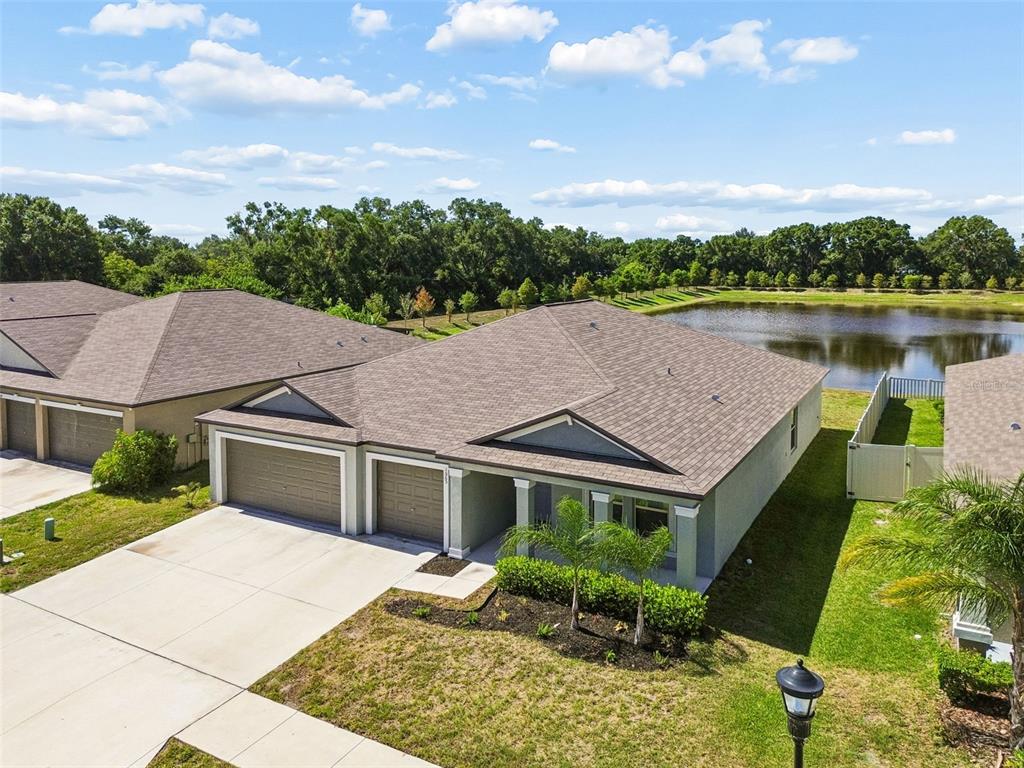 An aerial view of a single-story duplex home with a pond in the backyard — 1565 COLDING DRIVE, RUSKIN, FL