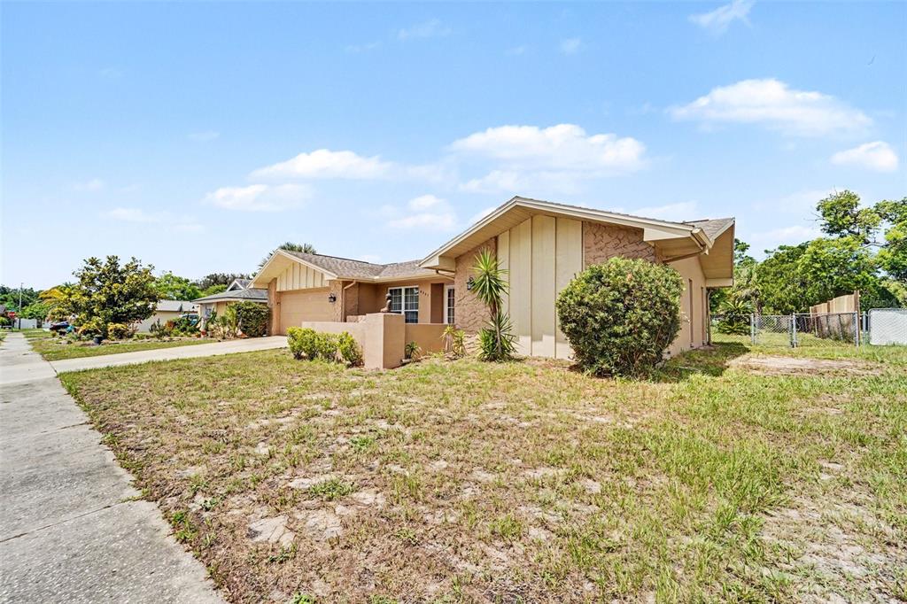 A single-story tan house with a gabled roof and a front yard with sparse grass — 8321 BRIARLEAF COURT, PORT RICHEY, FL