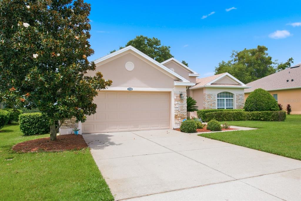 A single-story house with a beige exterior, stone accents, and a two-car garage — 3900 LIBERTY HILL DRIVE, CLERMONT, FL