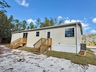 A single-story manufactured home with light siding and two sets of wooden stairs — 2629 NW 29TH TERRACE, BELL, FL