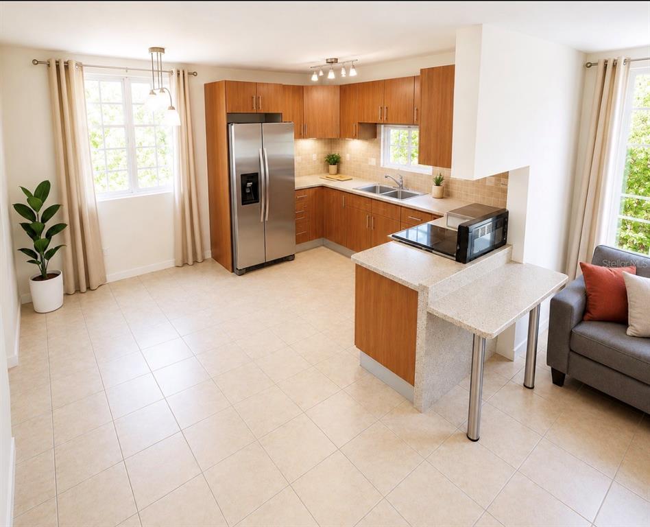 A kitchen with wood cabinets, stainless steel appliances, and a peninsula counter in an open room — 03 RIO MAMEYES, LUQUILLO, PR