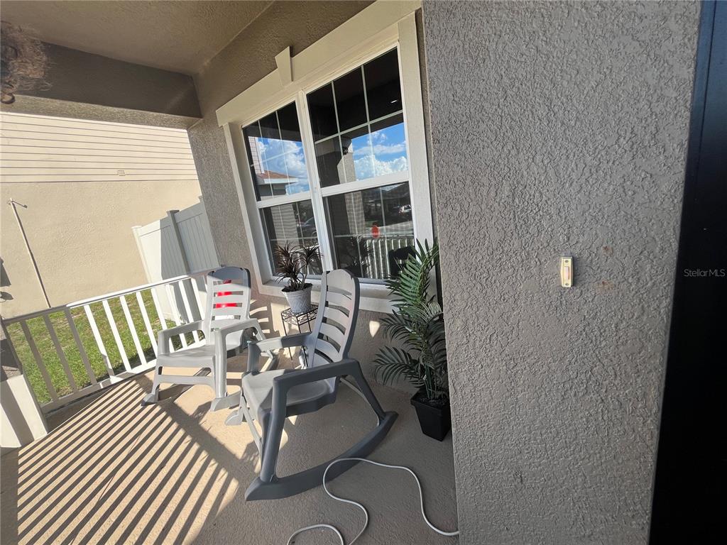 A side view of a house exterior with a grassy yard and a vinyl fence — 823 CHINOY ROAD, DAVENPORT, FL