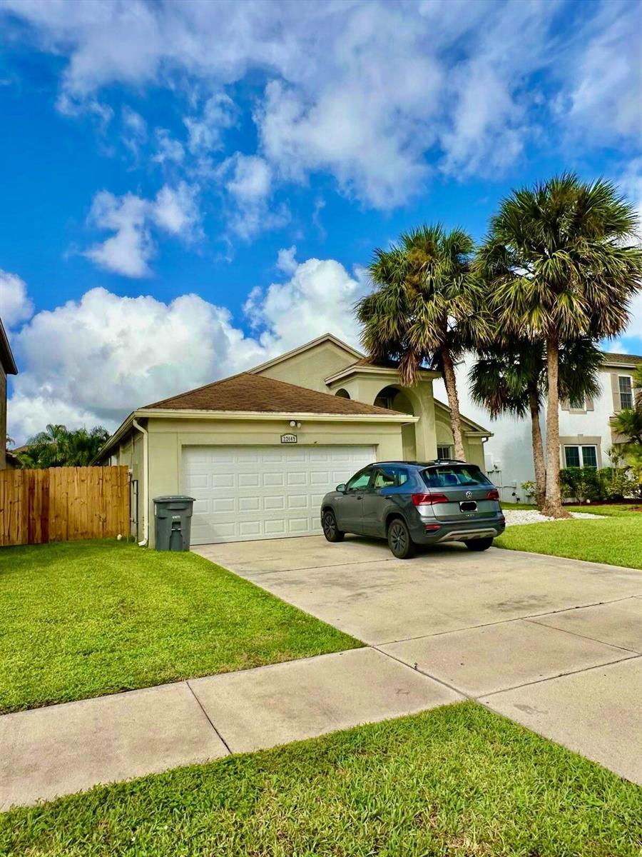 A gray SUV is parked in the driveway of a single-story house with palm trees — 22449 Middletown Drive, Boca Raton FL 33428, BOCA RATON, FL