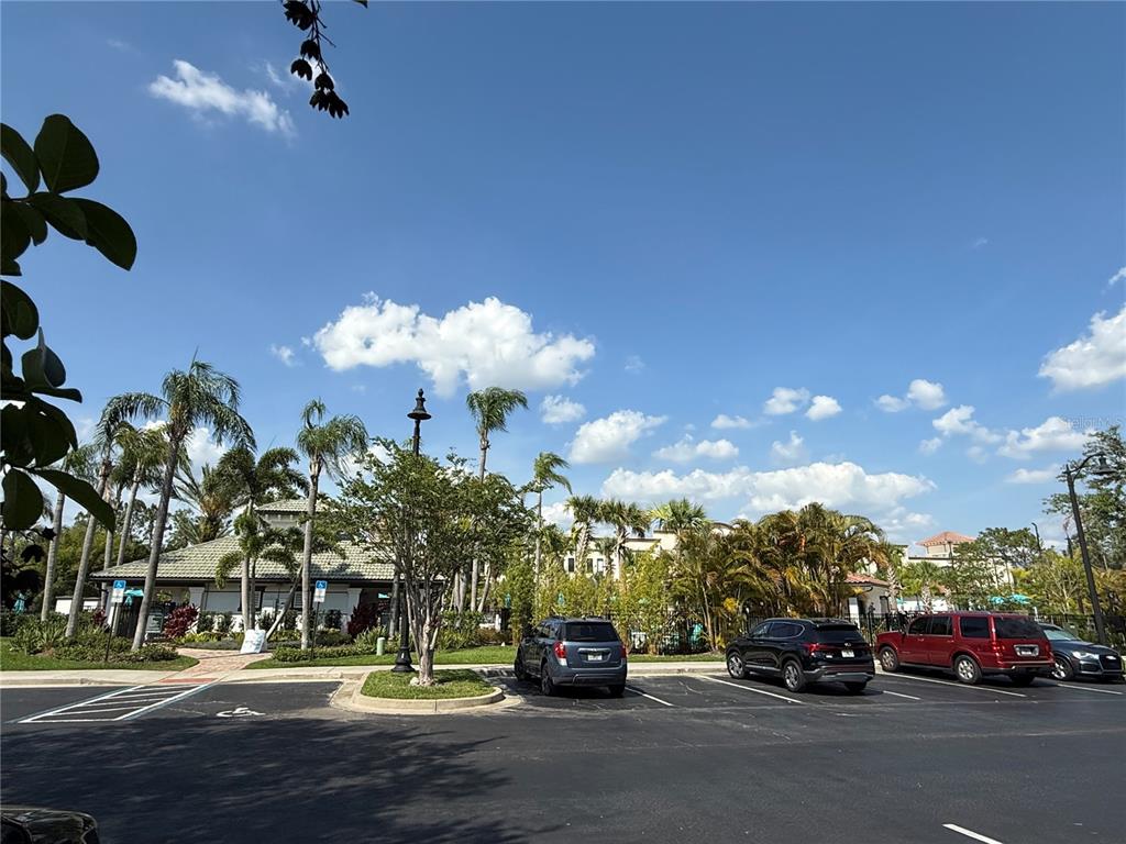 A parking lot sits in front of a building surrounded by palm trees and landscaping — 4024 BREAKVIEW DRIVE UNIT 105, ORLANDO, FL