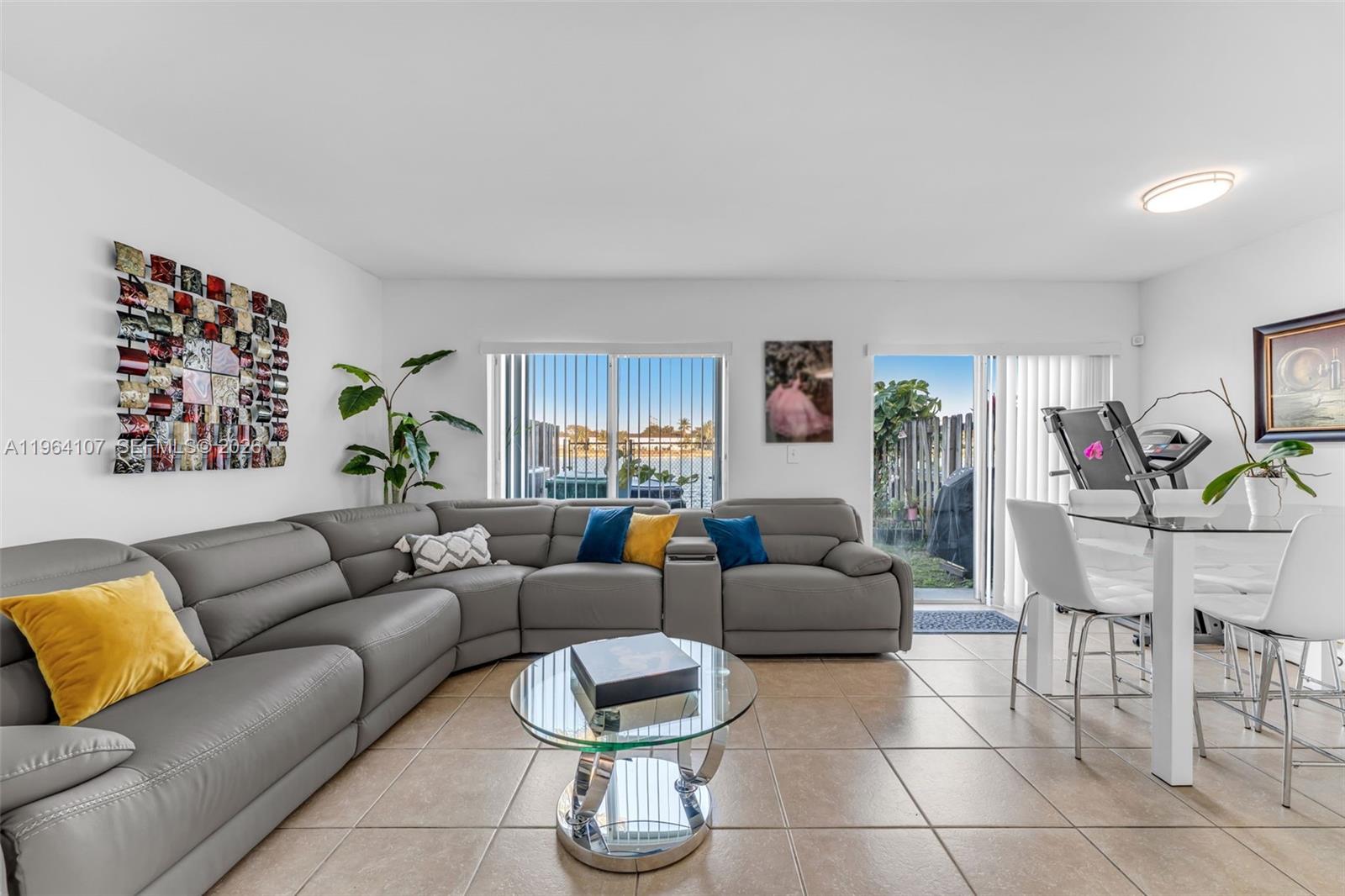 A living room features a grey sectional sofa, glass coffee table, and dining area — 17501 SW 140th Ct, Miami FL 33177, MIAMI, FL