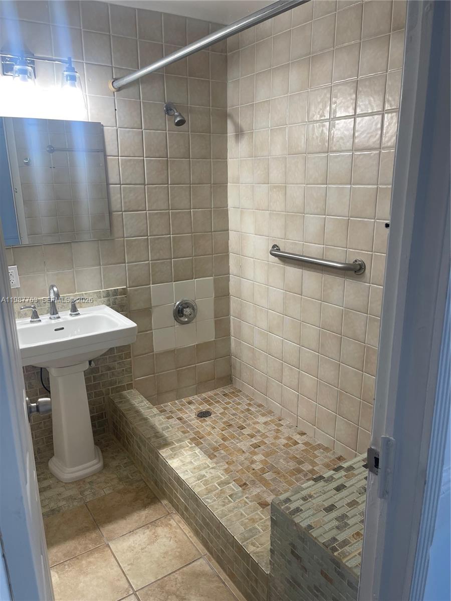 A bathroom features a pedestal sink, a tiled walk-in shower, and a grab bar — 20700 SW 122nd Ave, Miami FL 33177, MIAMI, FL