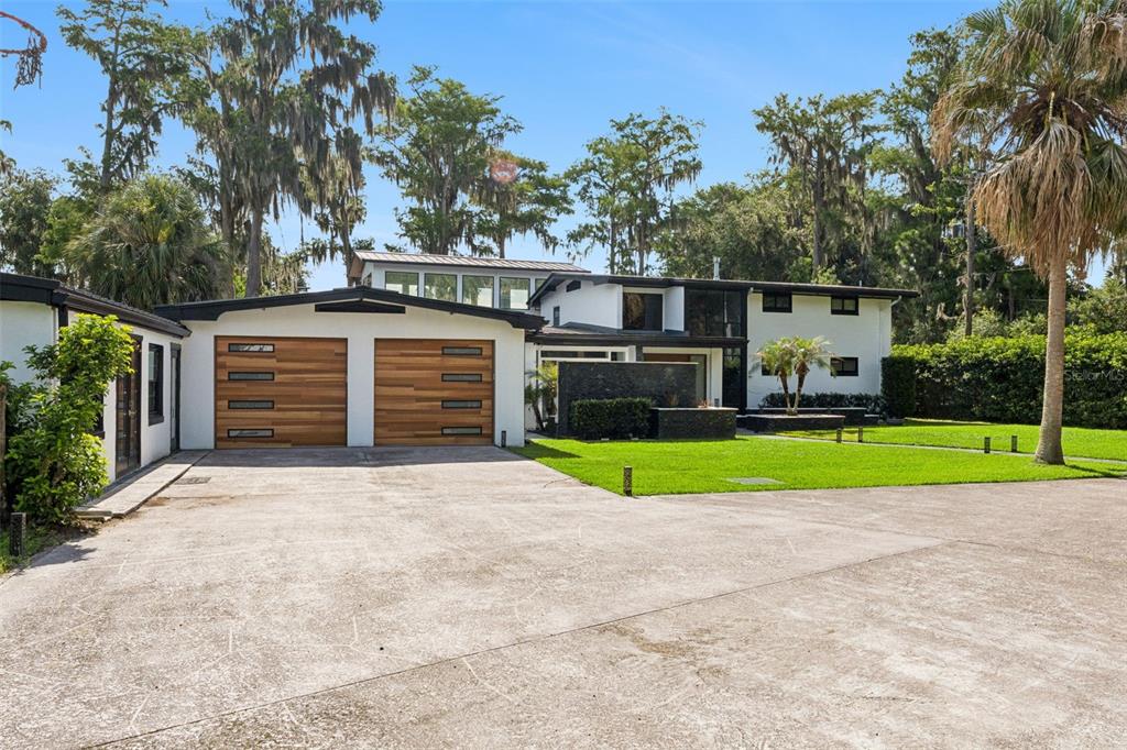 A two-story house with a two-car garage, white siding, and a large concrete driveway — 5583 JESSAMINE LANE, ORLANDO, FL
