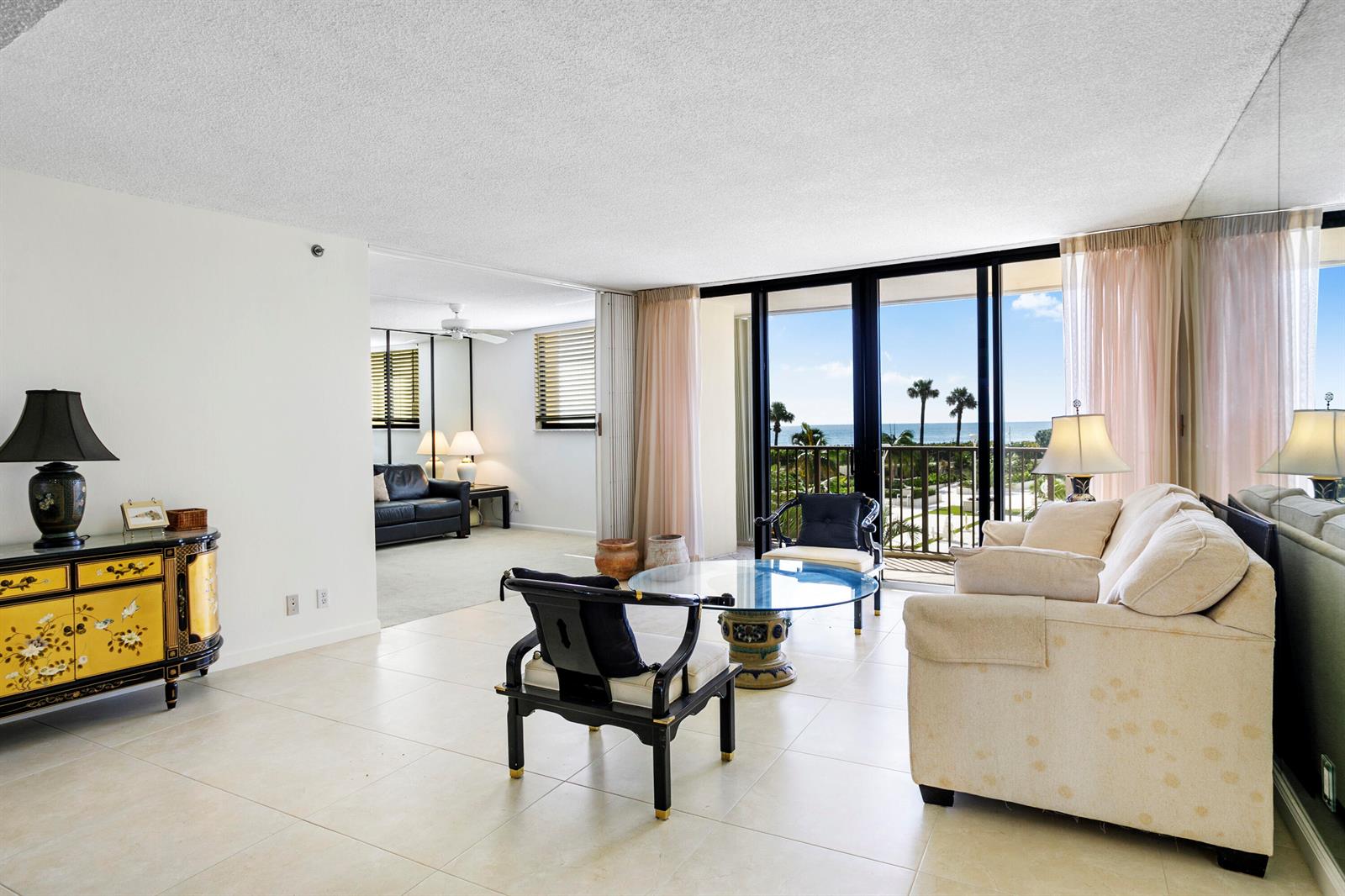 A living room with tile floors, a glass coffee table, and a view of the ocean — 200 Ocean Trail Way # 106, Jupiter FL 33477, JUPITER, FL